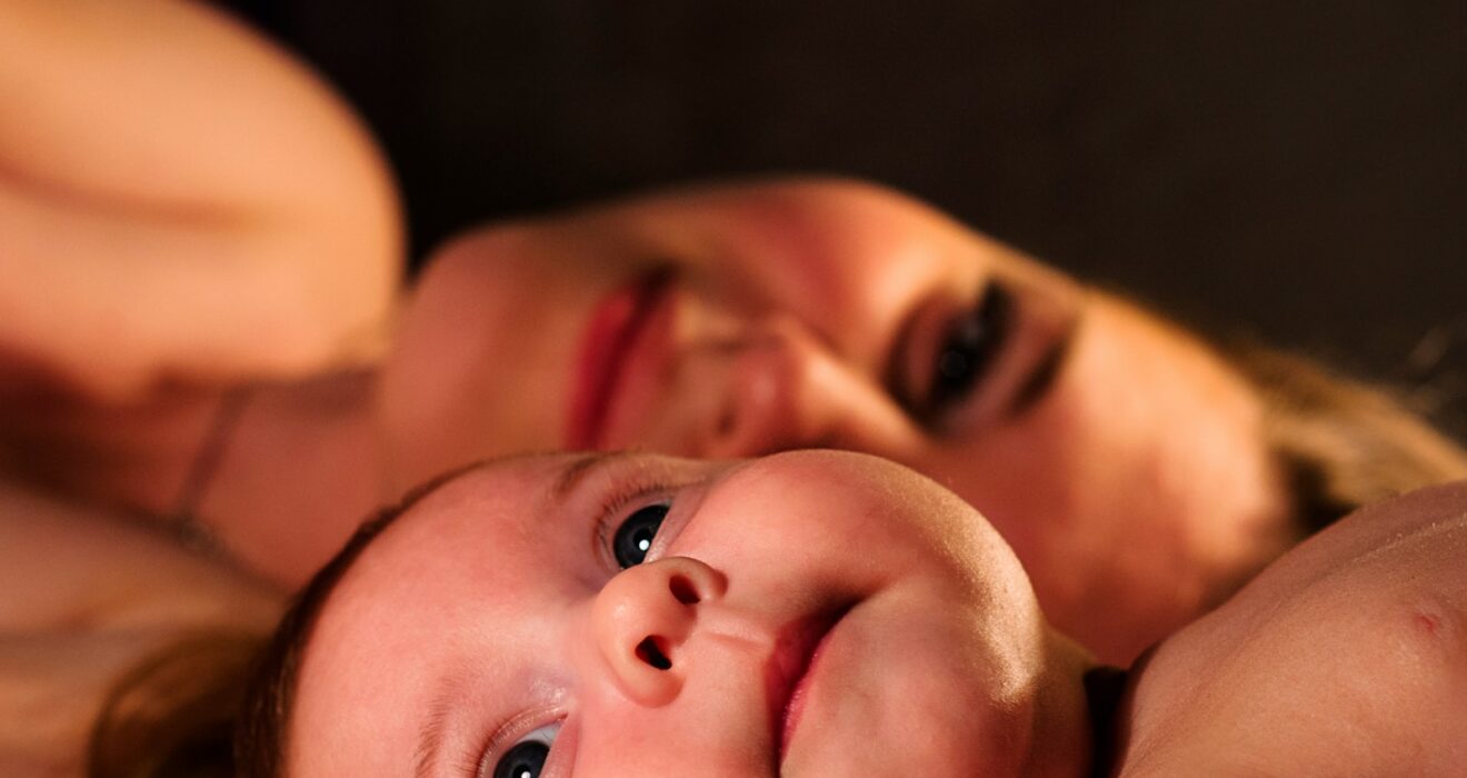 shallow focus photography of baby beside woman